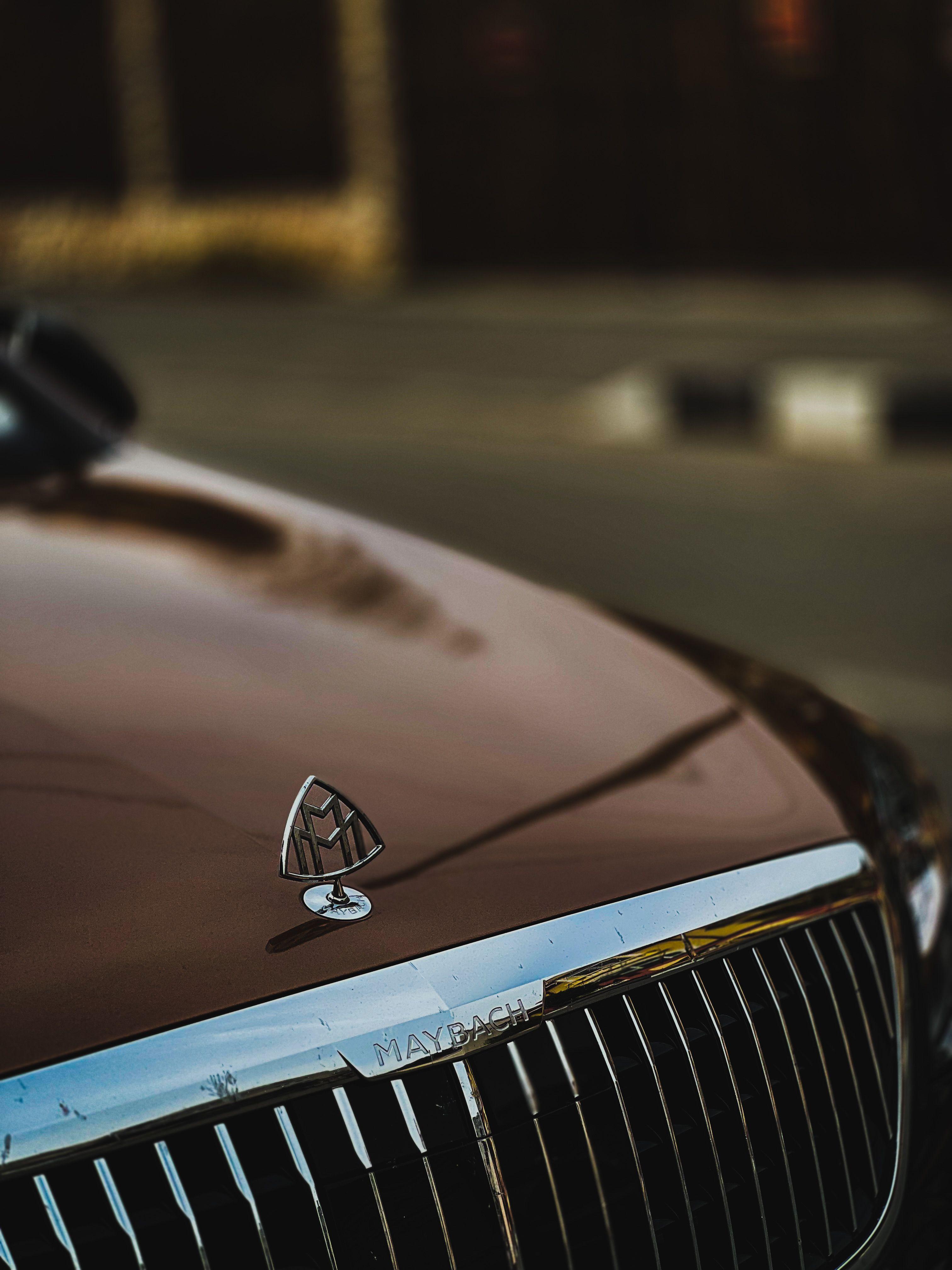 Close-up van het Mercedes-Maybach embleem op de motorkap, VIP chauffeursdienst bij nacht