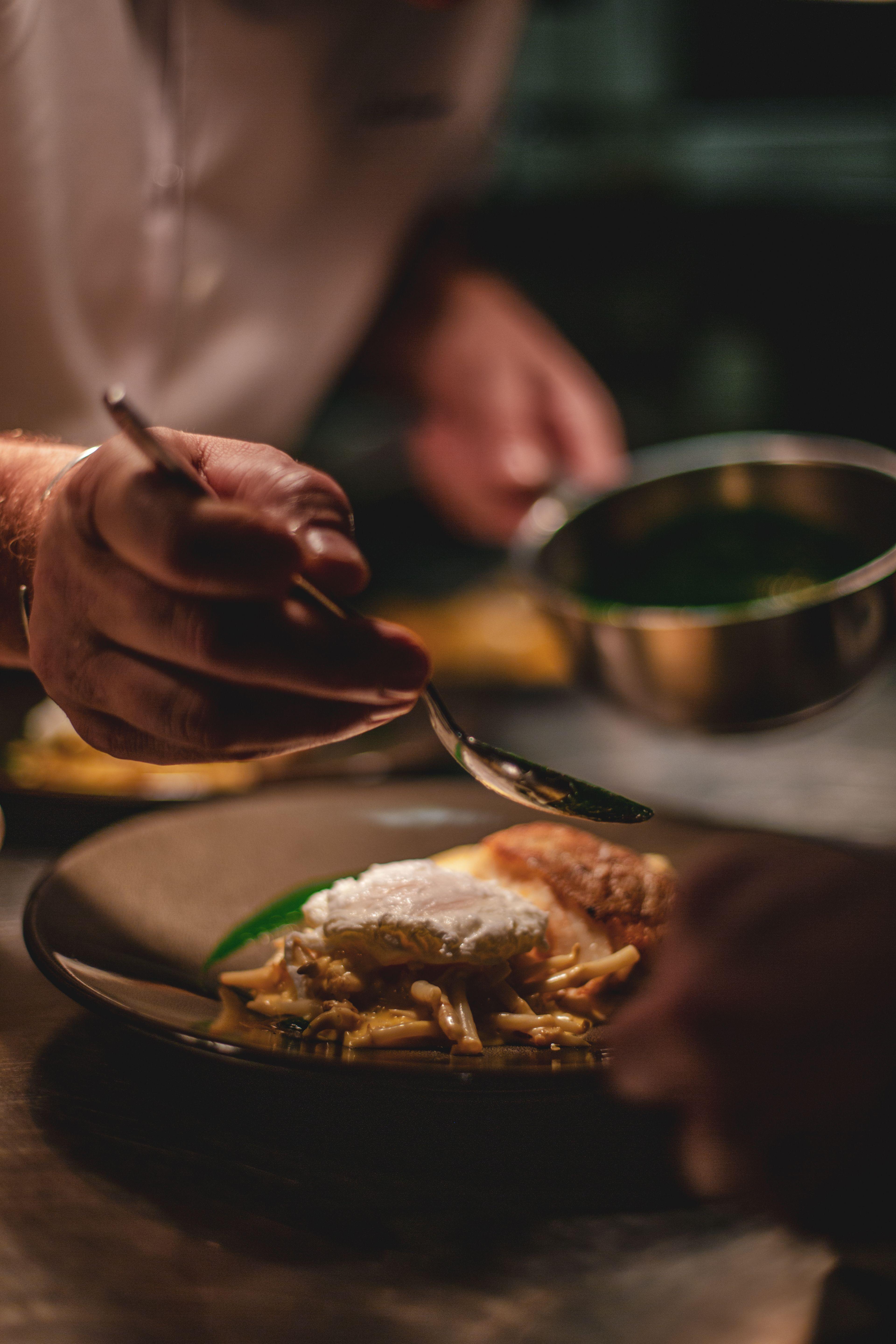 Chef-kok werkt een gerecht af voor een exclusieve restaurantreservering via onze concierge service